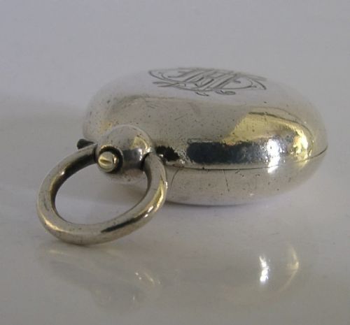 An open circular Victorian sterling silver sovereign case displaying an internal spring-loaded coin platform and hallmarks on the inner lid. View II