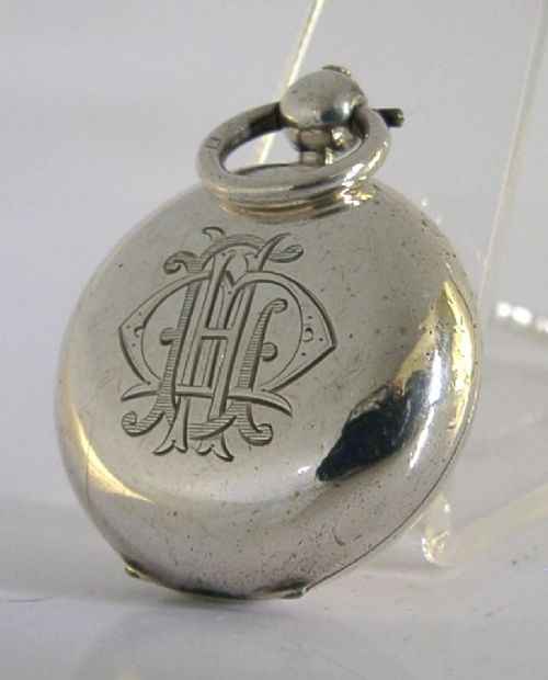 An open circular Victorian sterling silver sovereign case displaying an internal spring-loaded coin platform and hallmarks on the inner lid. View IV