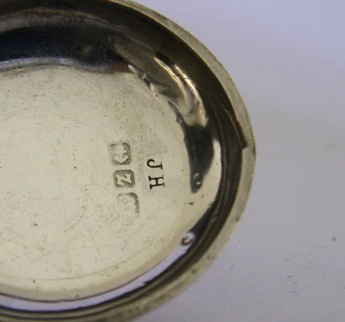 An open circular Victorian sterling silver sovereign case displaying an internal spring-loaded coin platform and hallmarks on the inner lid. View VI