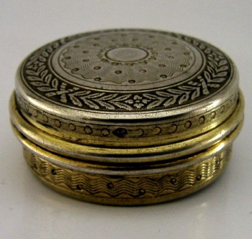 A circular French sterling silver gilt trinket box featuring engine-turned guilloche detailing and a decorative laurel leaf border. View V