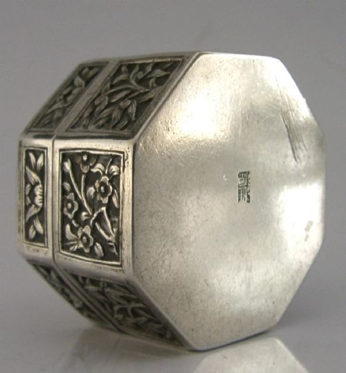 An octagonal Chinese export silver box featuring relief panels with floral and botanical motifs. View V