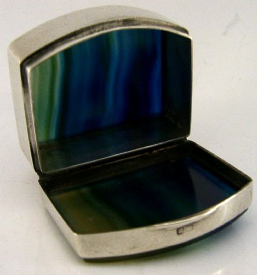 A small hinged sterling silver box featuring an arched lid mounted with a polished blue and yellow banded agate stone. View II