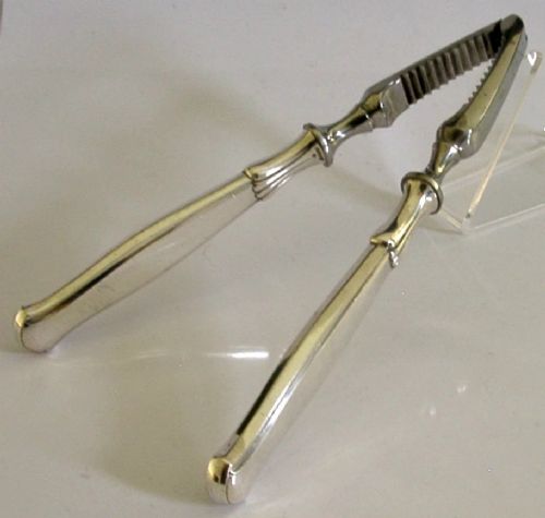 A pair of mid-century German nutcrackers featuring smooth silver handles and serrated metal jaws connected by a central hinge.