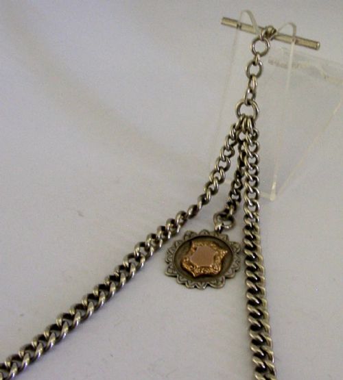 A solid sterling silver double Albert watch chain featuring curb links, a T-bar, two swivel clasps, and a decorative shield fob. View V