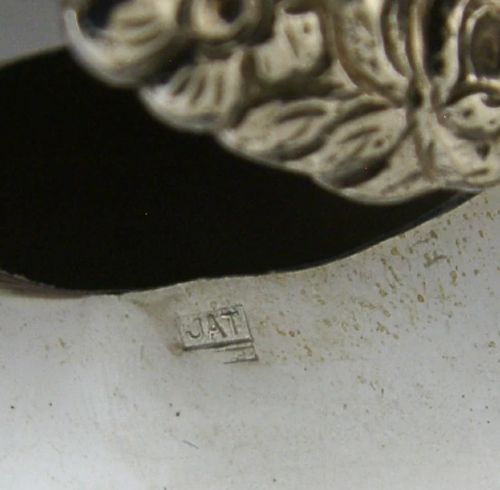 A sterling silver novelty cow creamer featuring a hollow cast body, a hinged lid decorated with floral motifs on the back, and a looped tail handle. View XI