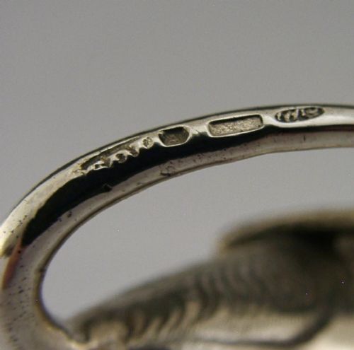 A sterling silver novelty cow creamer featuring a hollow cast body, a hinged lid decorated with floral motifs on the back, and a looped tail handle. View XII