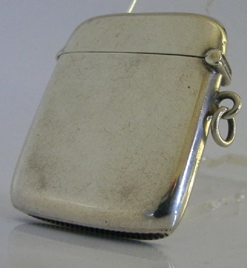 An Edwardian sterling silver vesta case featuring engraved military crests, text reading THE SCHOOL OF ARMS March. 1913, a side attachment ring, and a hinged lid. View VI