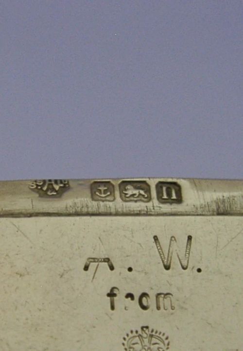 An Edwardian sterling silver vesta case featuring engraved military crests, text reading THE SCHOOL OF ARMS March. 1913, a side attachment ring, and a hinged lid. View VII