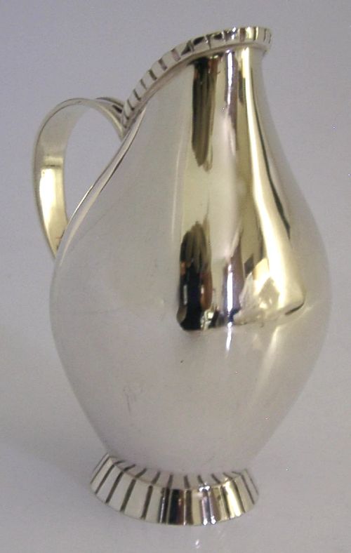 A pear-shaped mid-century sterling silver cream jug featuring a fluted rim, a matching fluted foot ring, and a single loop handle. View IV