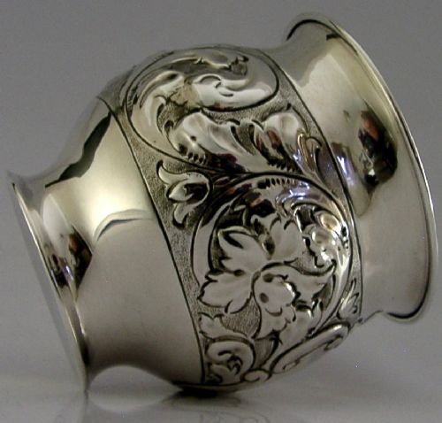 An Edwardian sterling silver fern pot featuring detailed embossed acanthus leaf and scroll decoration around the body with a polished flared rim. View VII