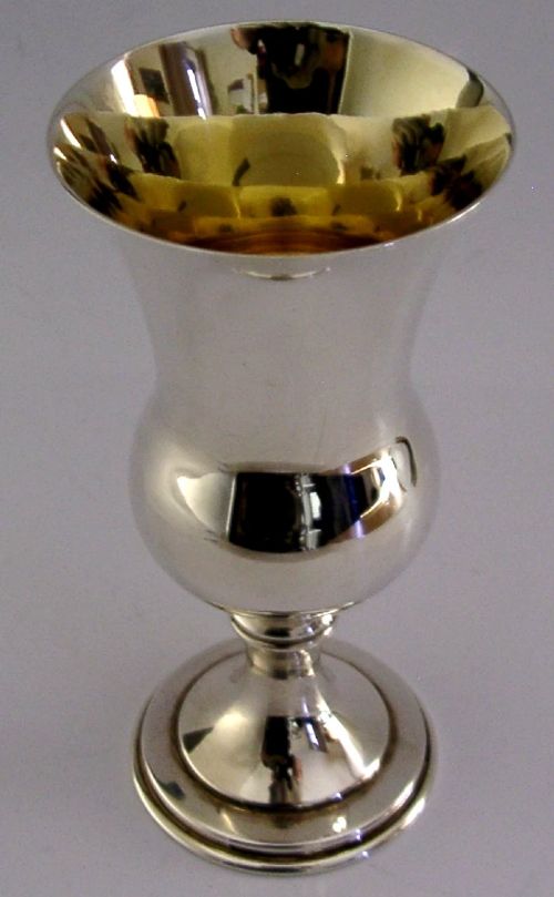 A sterling silver wine goblet featuring a bulbous bowl with a flared rim, a gilt interior, a short turned stem, and a stepped circular foot. View V