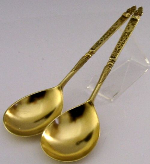 A pair of Victorian sterling silver gilt serving spoons featuring oval bowls and detailed cast handles with grotesque mask and scroll motifs. View VI