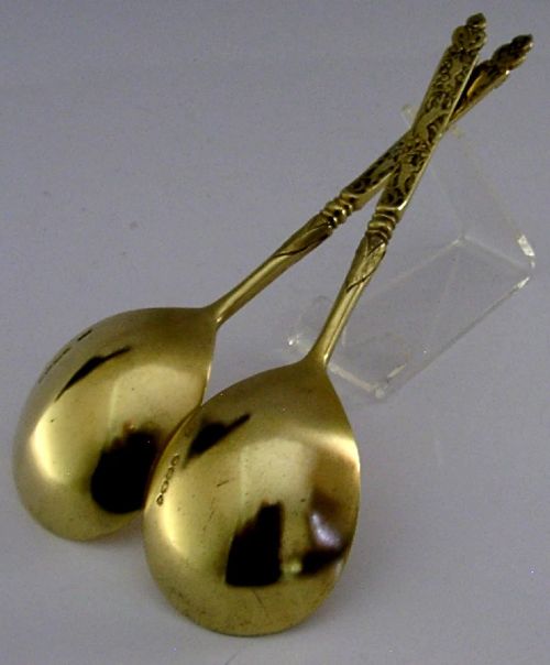 A pair of Victorian sterling silver gilt serving spoons featuring oval bowls and detailed cast handles with grotesque mask and scroll motifs. View VII