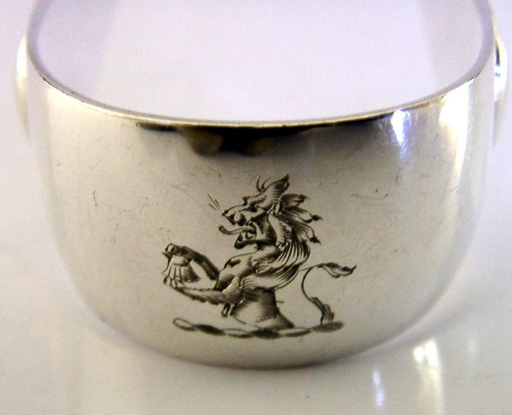 Edwardian sterling silver serving tongs featuring slotted rectangular blades and an engraved crest on the curved handle. View III