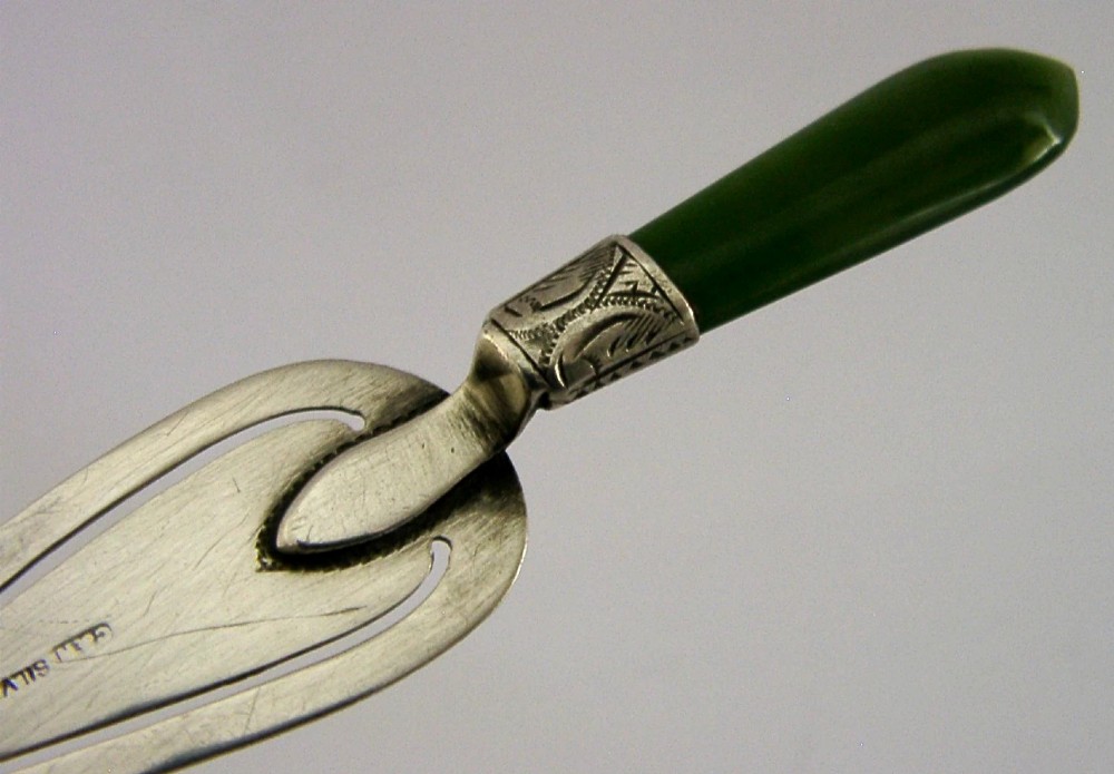 An Edwardian sterling silver trowel-shaped bookmark featuring a cutout page clip and a smooth dark green jade handle. View II