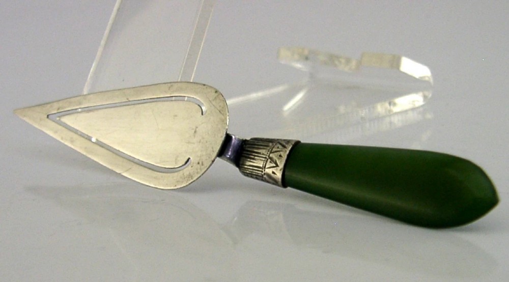 An Edwardian sterling silver trowel-shaped bookmark featuring a cutout page clip and a smooth dark green jade handle. View IV