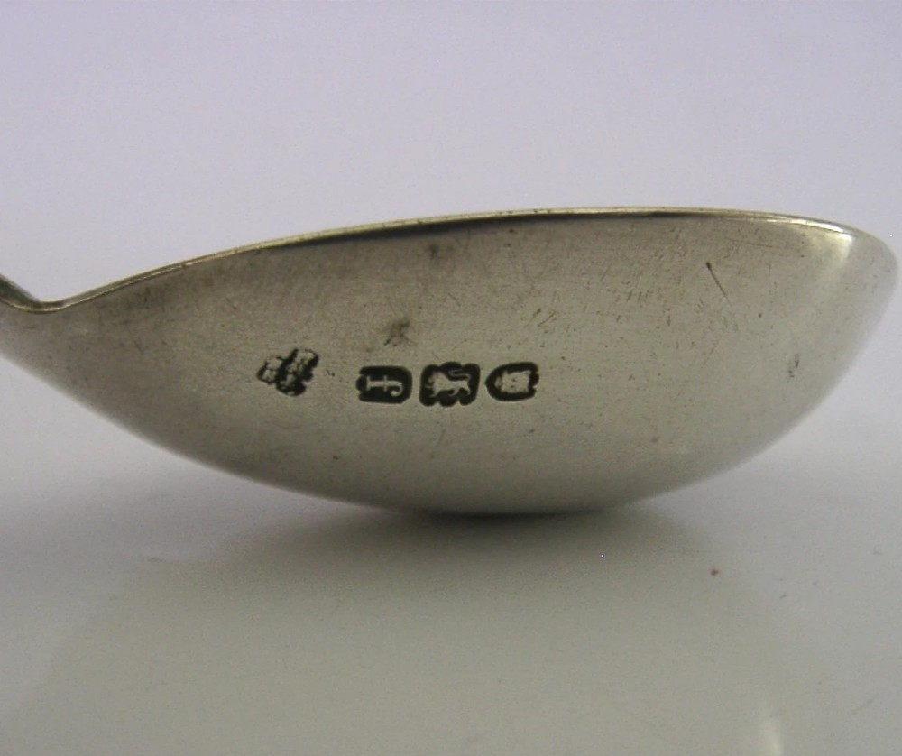 An Edwardian sterling silver tea caddy spoon with a smooth ovate bowl and an embossed handle depicting an angel holding a harp. View II