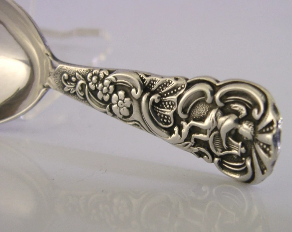 An Edwardian sterling silver tea caddy spoon with a smooth ovate bowl and an embossed handle depicting an angel holding a harp. View III