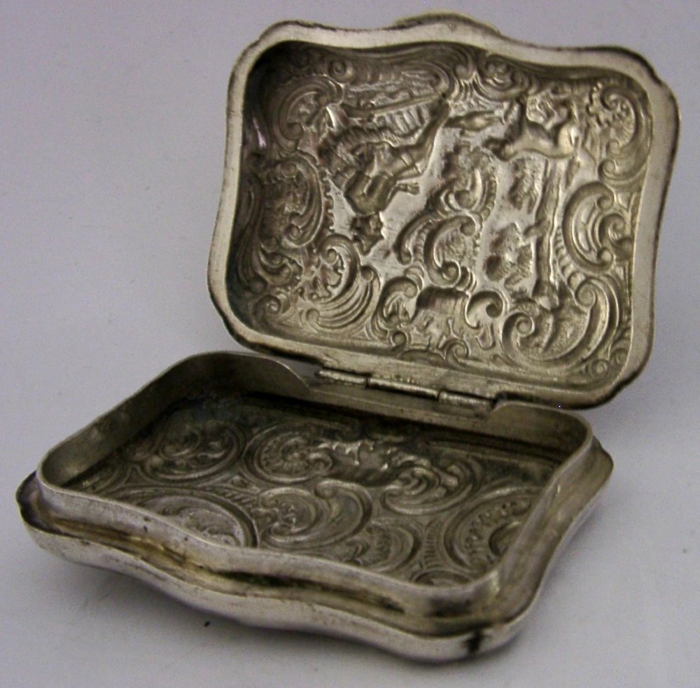 An antique rectangular silver box with intricate repousse scrollwork depicting a hunter seated beside a hound in a woodland setting. View VIII
