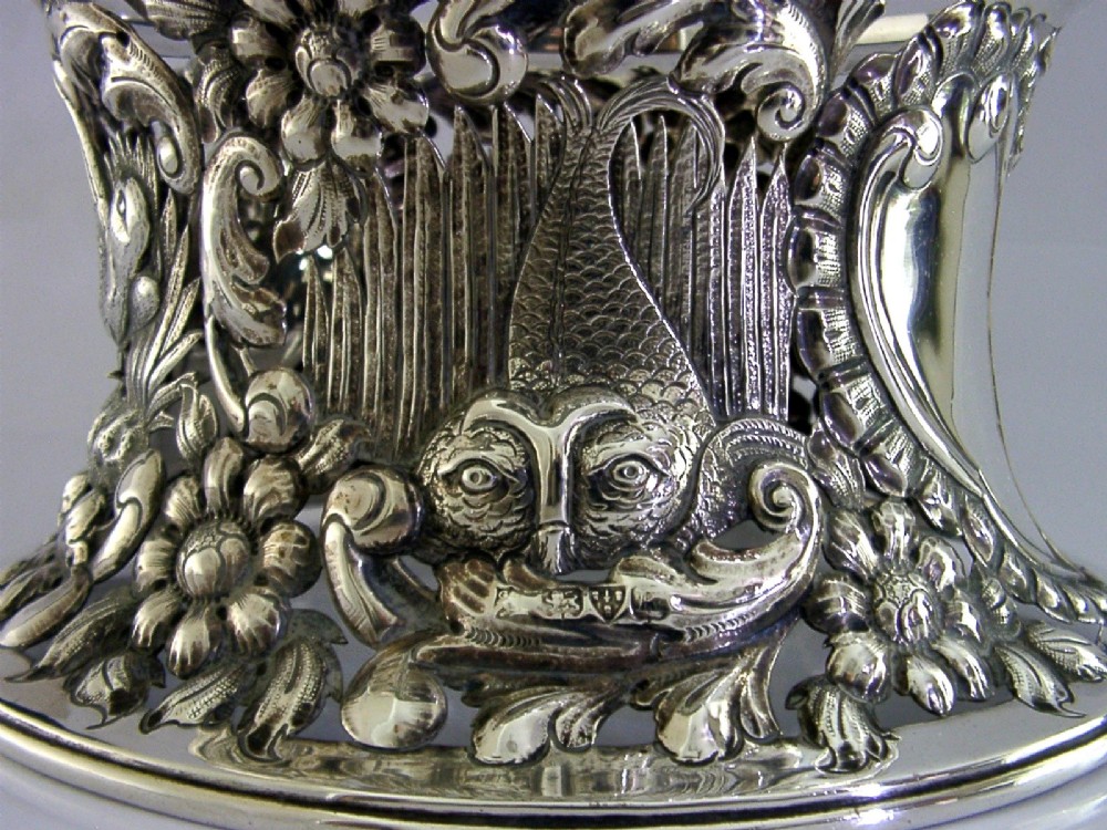 An hourglass-shaped sterling silver dish ring featuring intricately pierced fretwork with floral motifs, scrolls, and marine life details. View II