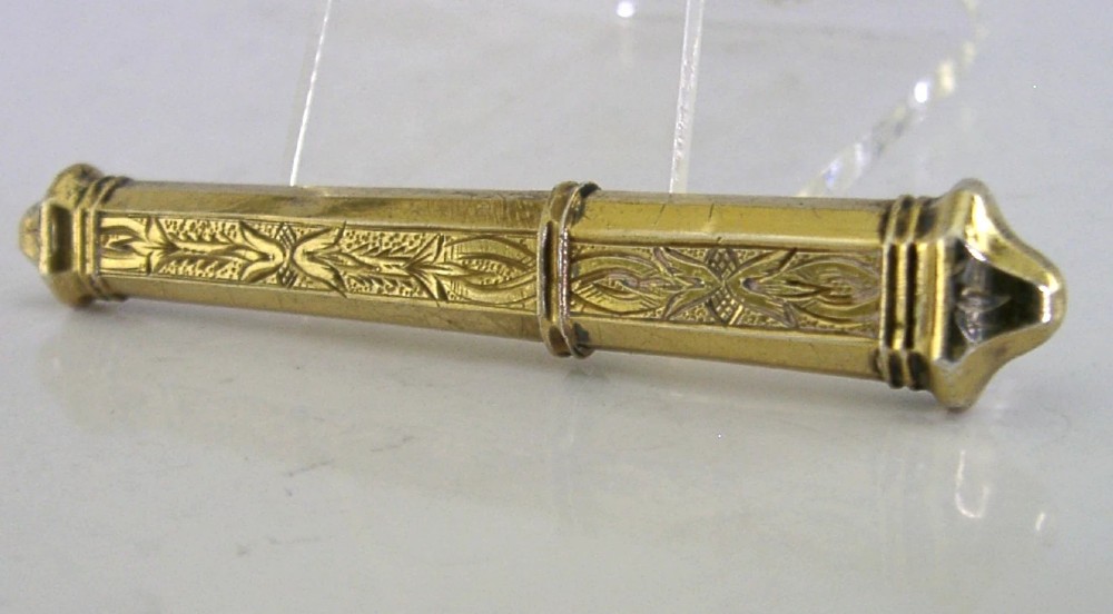An antique French silver gilt needle case featuring engraved foliage and moulded finials. View V