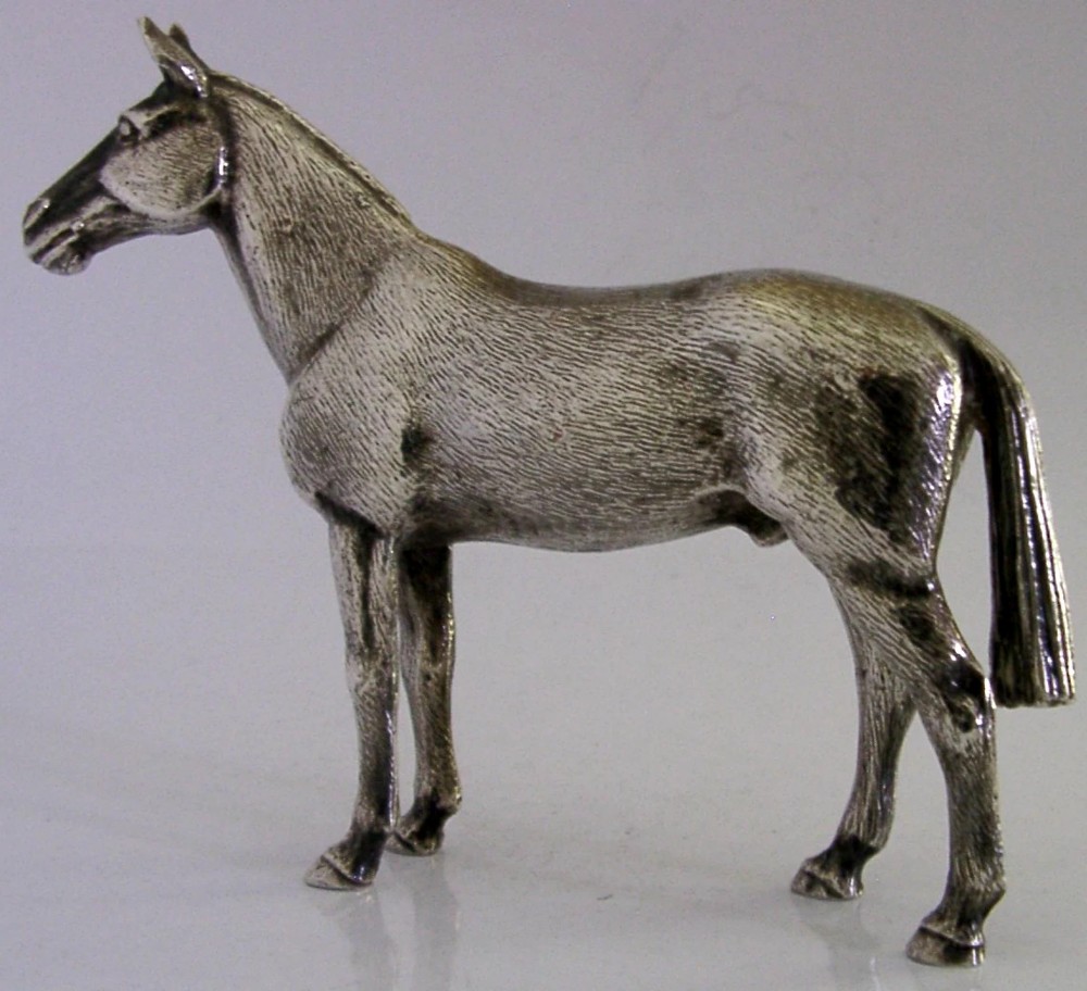 A silver-plated metal figure depicting a standing horse with detailed textured fur, erect ears, and a refined posture. View IV