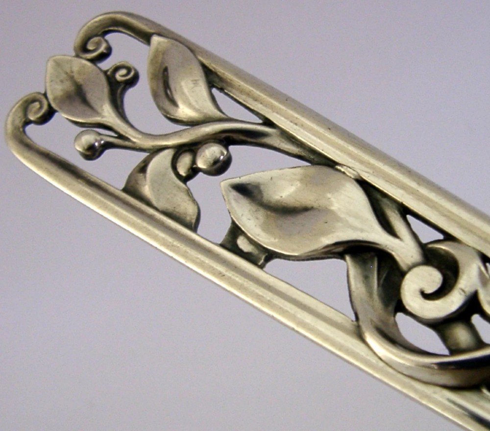 A Danish solid silver sauce ladle featuring a double-lipped deep bowl and an intricate openwork carved leaf handle. View IV