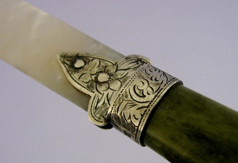 An Edwardian letter opener featuring a polished green Connemara marble handle, an engraved sterling silver ferrule, and a tapered mother-of-pearl blade. View II