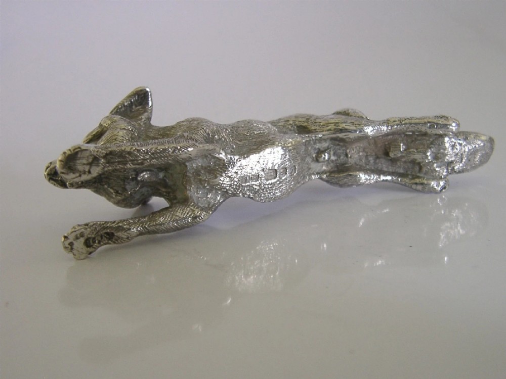 A solid sterling silver figurine depicting a fox in a low running pose with textured fur and detailed features. View X