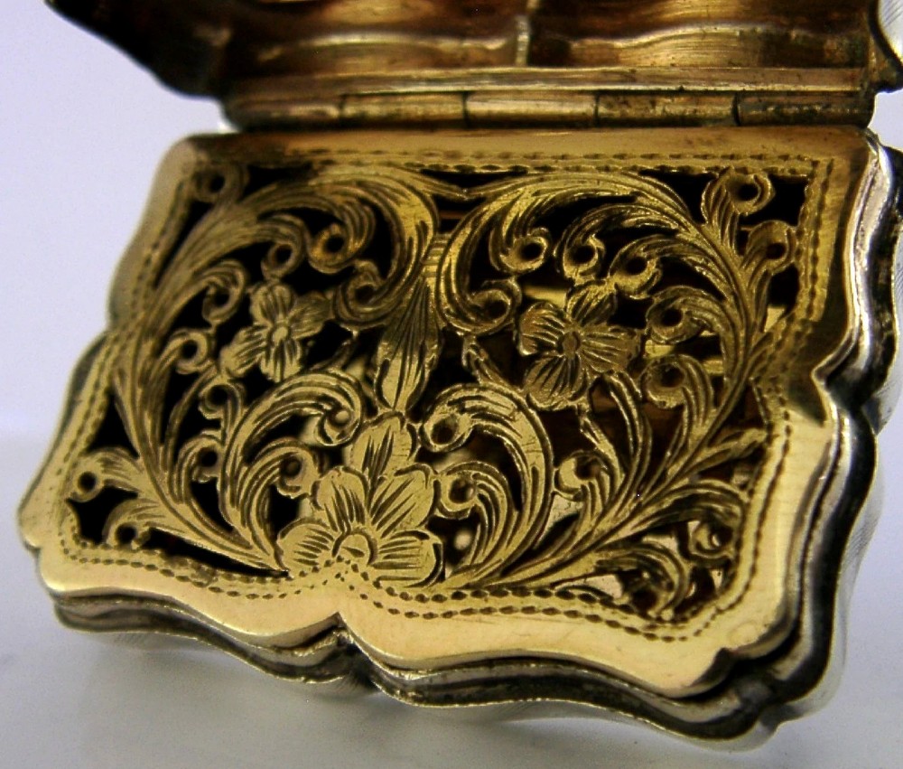 An open Victorian sterling silver vinaigrette box by Nathaniel Mills featuring a scalloped edge, cross-hatch engraving, and an internal hinged pierced gilt grill. View II