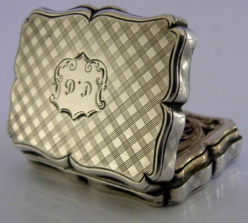 An open Victorian sterling silver vinaigrette box by Nathaniel Mills featuring a scalloped edge, cross-hatch engraving, and an internal hinged pierced gilt grill. View III