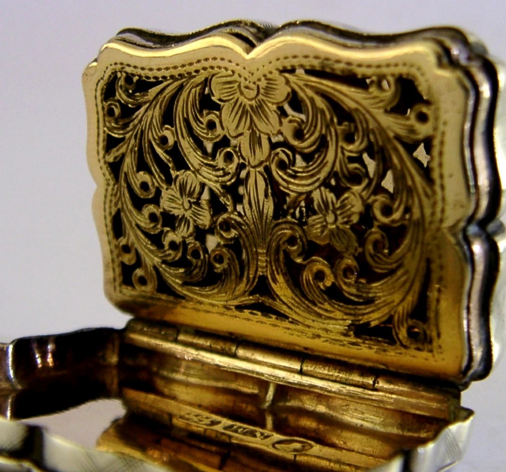 An open Victorian sterling silver vinaigrette box by Nathaniel Mills featuring a scalloped edge, cross-hatch engraving, and an internal hinged pierced gilt grill. View V