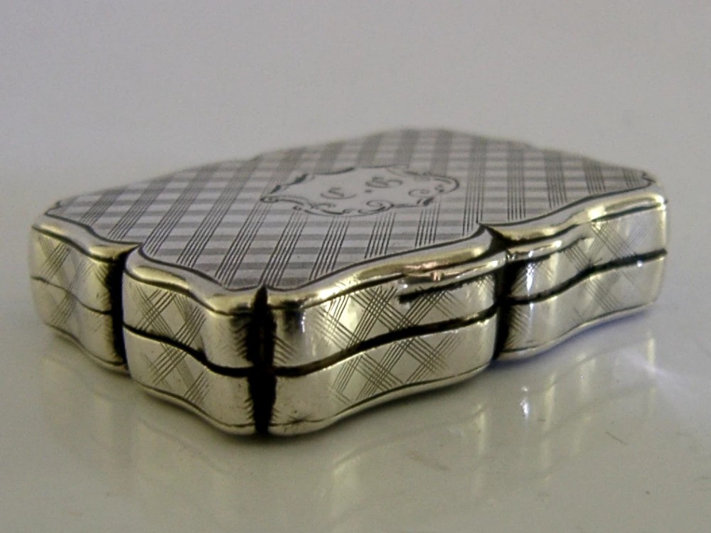 An open Victorian sterling silver vinaigrette box by Nathaniel Mills featuring a scalloped edge, cross-hatch engraving, and an internal hinged pierced gilt grill. View VIII