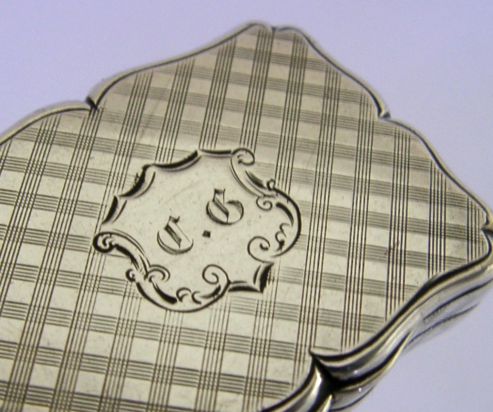 An open Victorian sterling silver vinaigrette box by Nathaniel Mills featuring a scalloped edge, cross-hatch engraving, and an internal hinged pierced gilt grill. View X