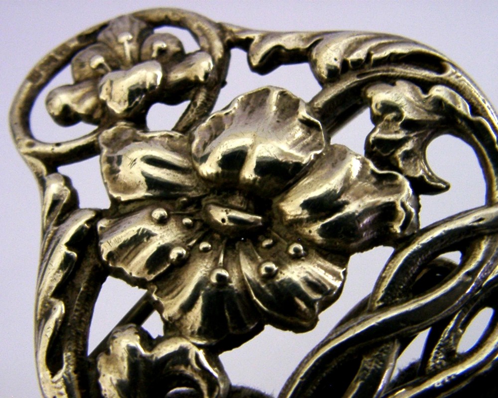 A two-piece cast sterling silver Art Nouveau belt buckle featuring relief floral and foliage motifs. View IV