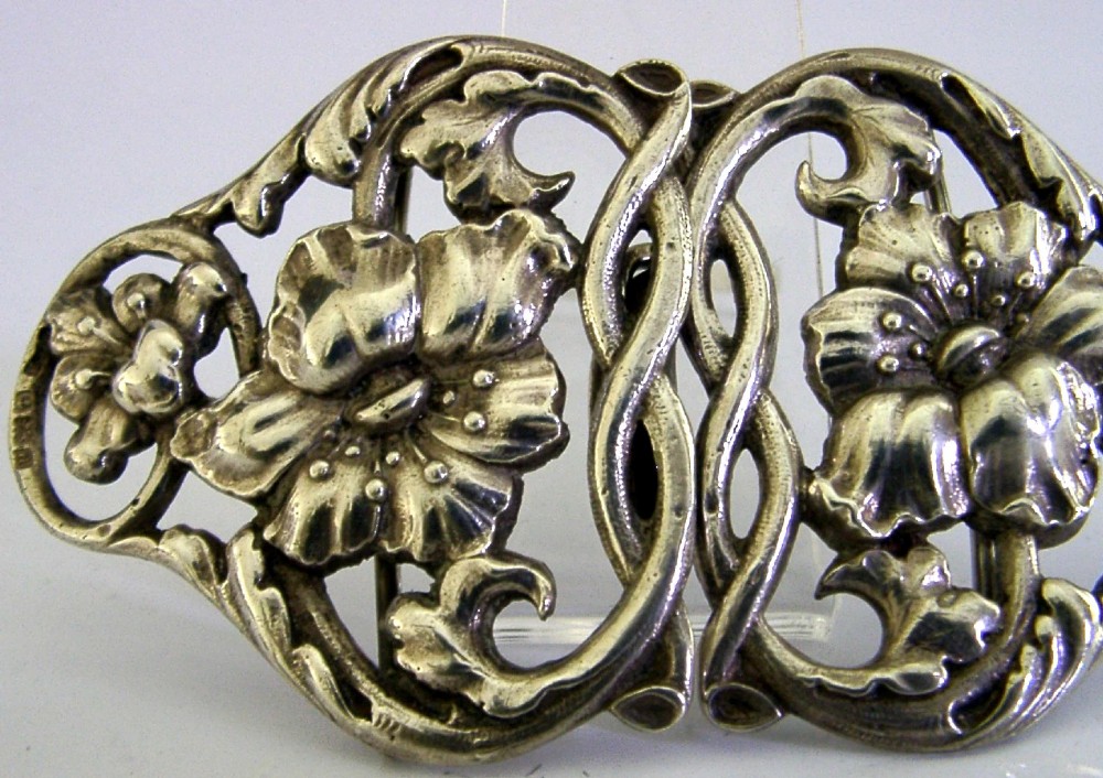 A two-piece cast sterling silver Art Nouveau belt buckle featuring relief floral and foliage motifs. View V