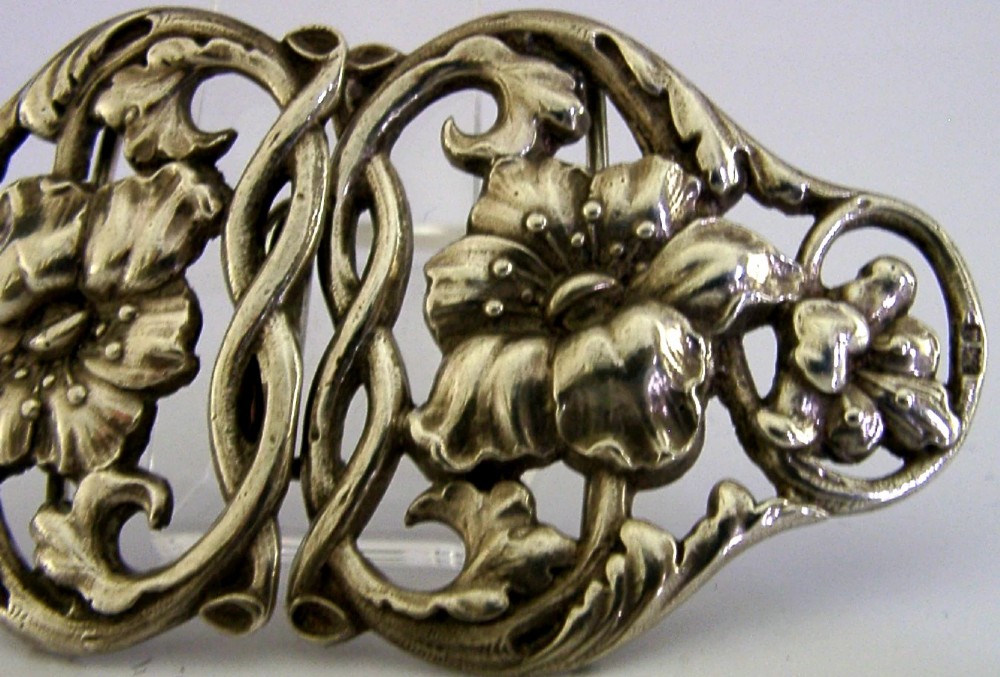 A two-piece cast sterling silver Art Nouveau belt buckle featuring relief floral and foliage motifs. View VI