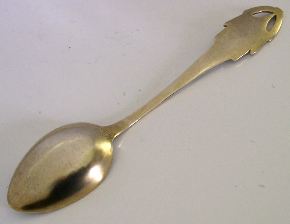 An antique solid silver souvenir spoon featuring a hand-painted enamelled bowl depicting a portrait of a Swiss woman in traditional attire, complete with a green enamelled handle terminal. View IX