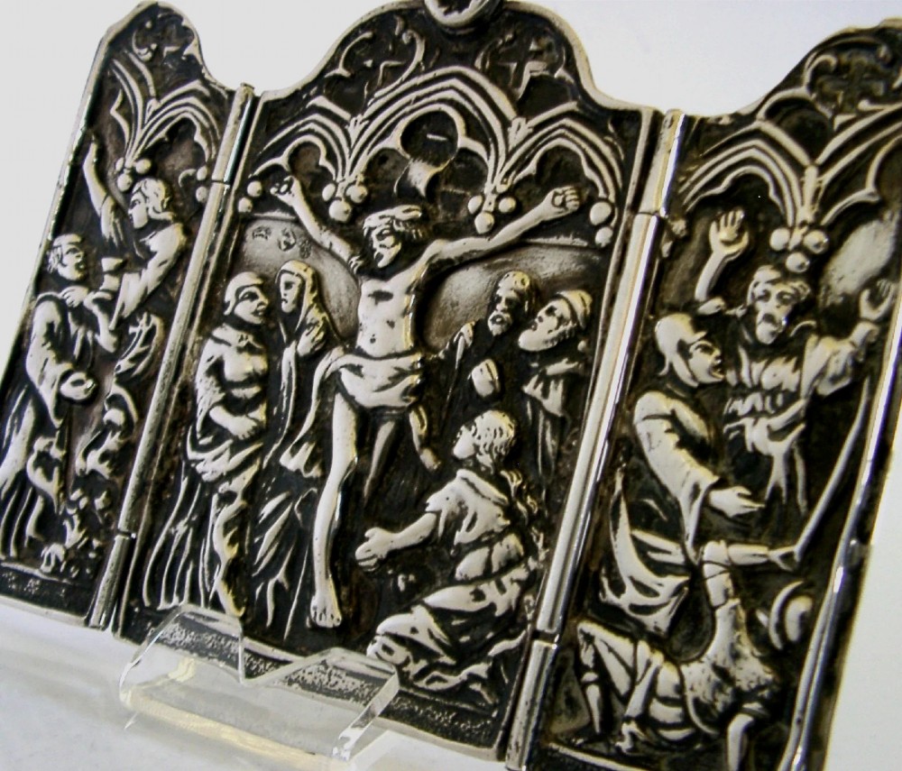 A late nineteenth-century German Hanau silver folding travel triptych featuring a central relief depiction of the Crucifixion flanked by hinged side panels within Gothic arches. View II