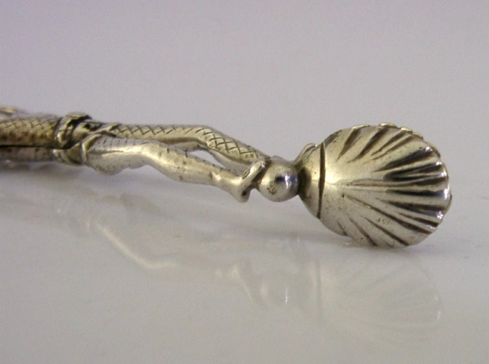 An Edwardian sterling silver sugar nip designed in the detailed shape of a harlequin jester with scissor-action handles and shell-shaped grips. View VI