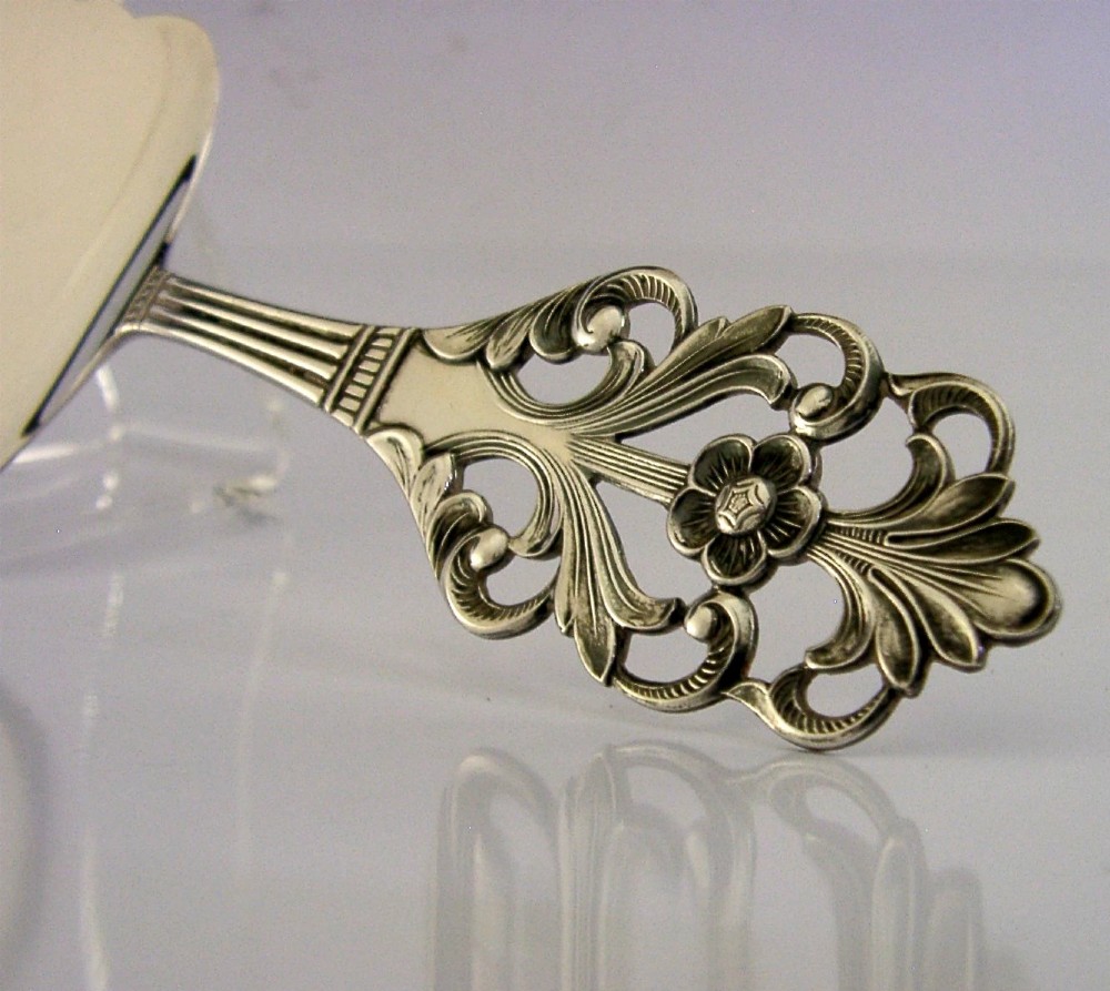 A Norwegian 830 solid silver cake server featuring an openwork scrollwork handle and an engraved floral pattern on the flat blade. View II