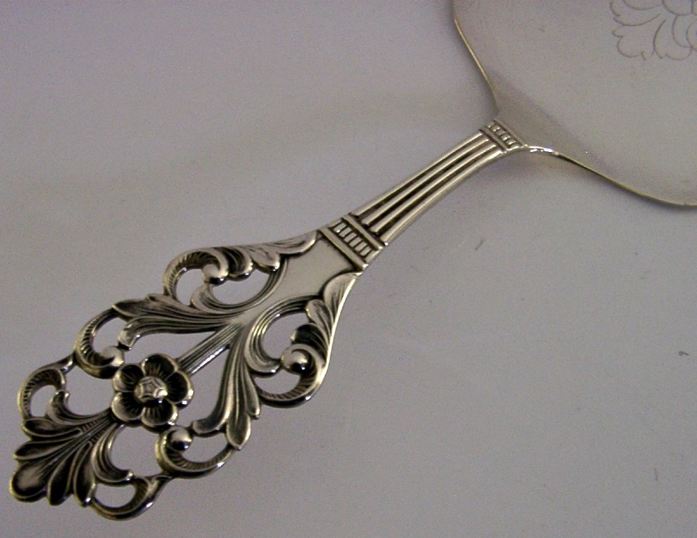 A Norwegian 830 solid silver cake server featuring an openwork scrollwork handle and an engraved floral pattern on the flat blade. View III