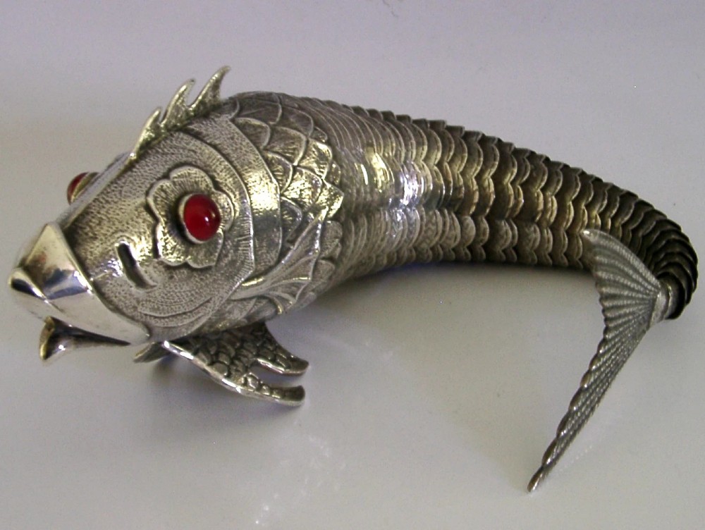 A mid-twentieth-century Spanish 915 silver articulated fish figure with engraved scales, structured fins, and a red cabochon eye. View VI