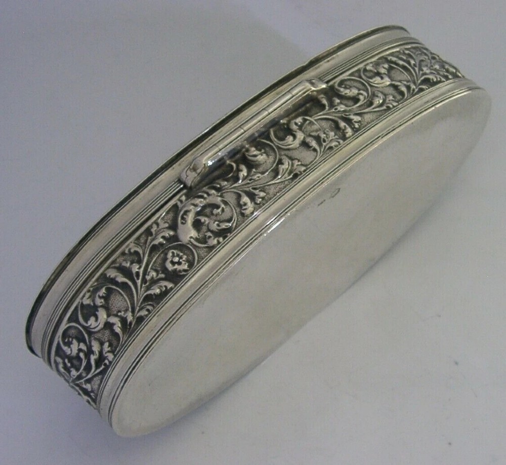 An oval solid silver desk box decorated with high-relief repousse relief depicting traditional Dutch tavern dancers and musicians. View X