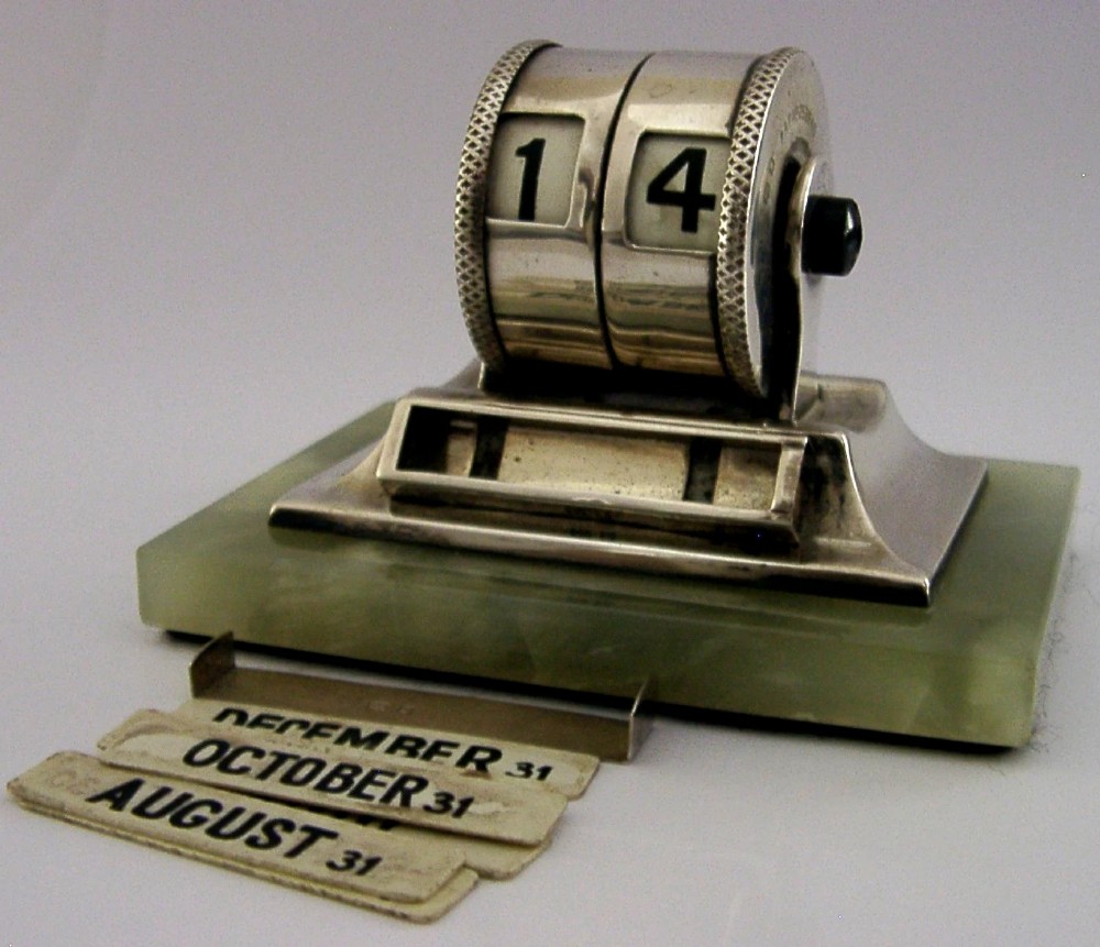 An Art Deco sterling silver mechanical perpetual desk calendar featuring double number rollers mounted on a rectangular pale green onyx base. View IV