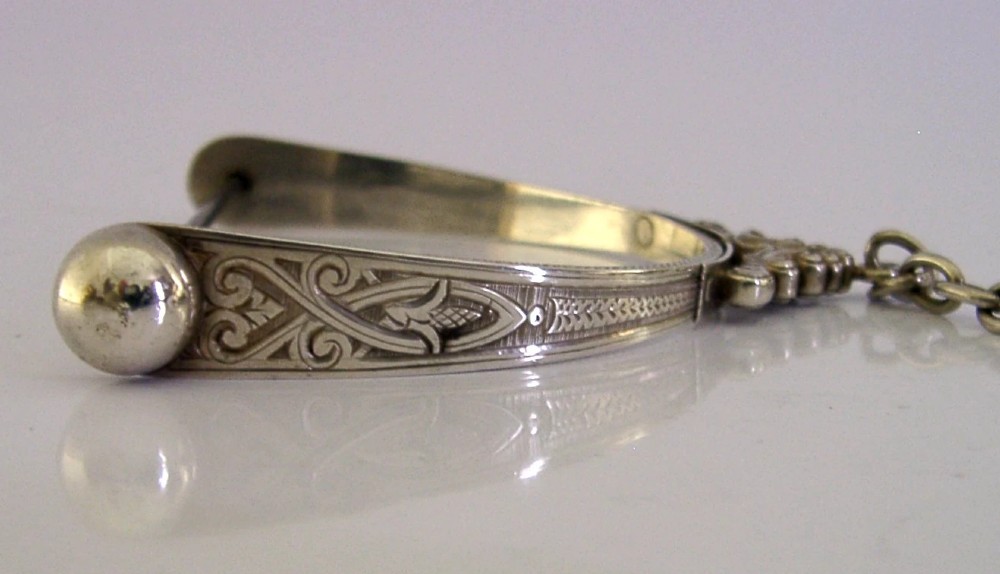 A Victorian sterling silver chatelaine thread spool holder featuring engraved scrollwork motifs and suspension chains. View VIII