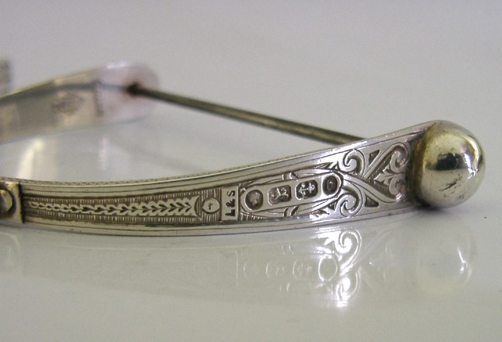A Victorian sterling silver chatelaine thread spool holder featuring engraved scrollwork motifs and suspension chains. View XIII