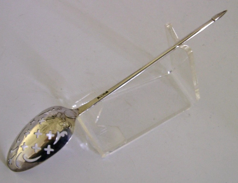 An 18th-century Georgian sterling silver mote spoon with a hand-pierced bowl featuring scroll cutouts and a long stem ending in a pointed tip. View IV