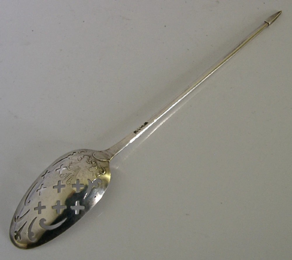 An 18th-century Georgian sterling silver mote spoon with a hand-pierced bowl featuring scroll cutouts and a long stem ending in a pointed tip. View VII