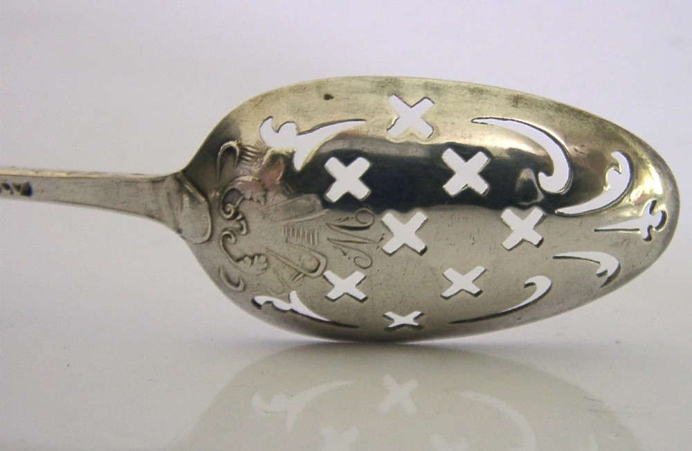An 18th-century Georgian sterling silver mote spoon with a hand-pierced bowl featuring scroll cutouts and a long stem ending in a pointed tip. View IX